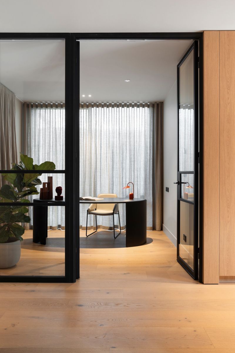 Avoca Bay oak flooring at a black-framed curved glass doorway in Kew.