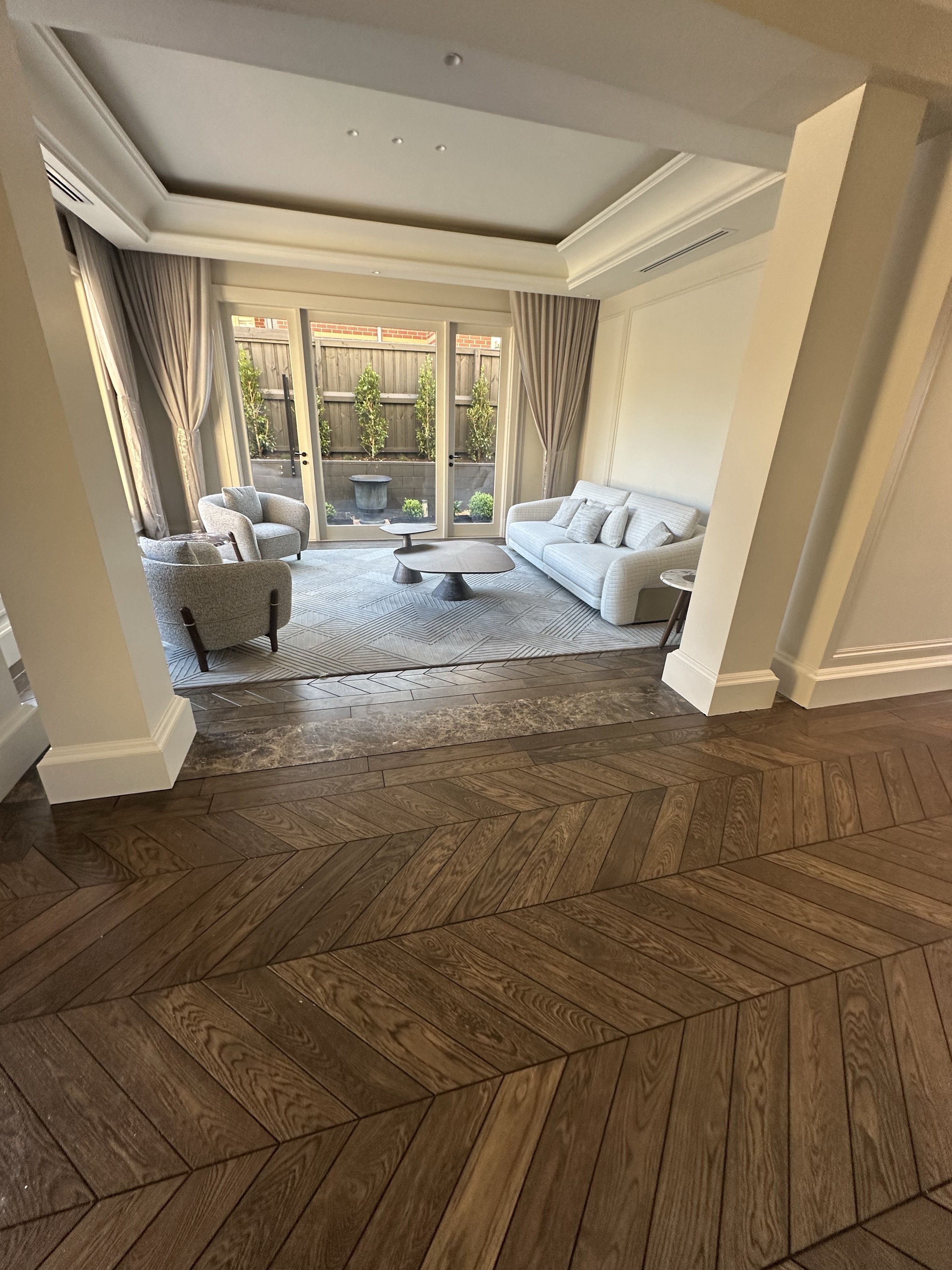 Solid oak chevron flooring connecting a Balwyn North hallway and living room.