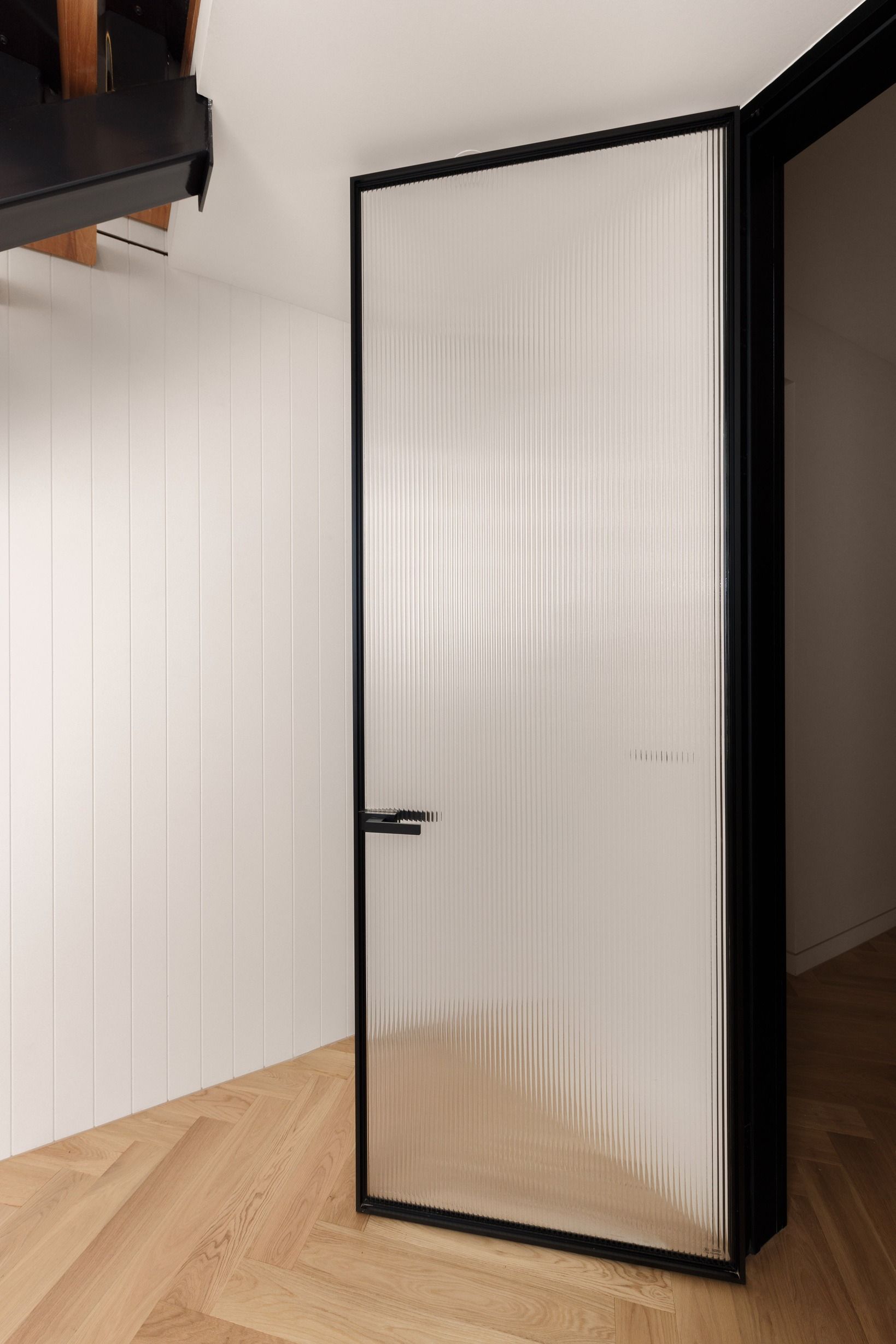 Natural Oak flooring beside a black-framed internal door in Kew.