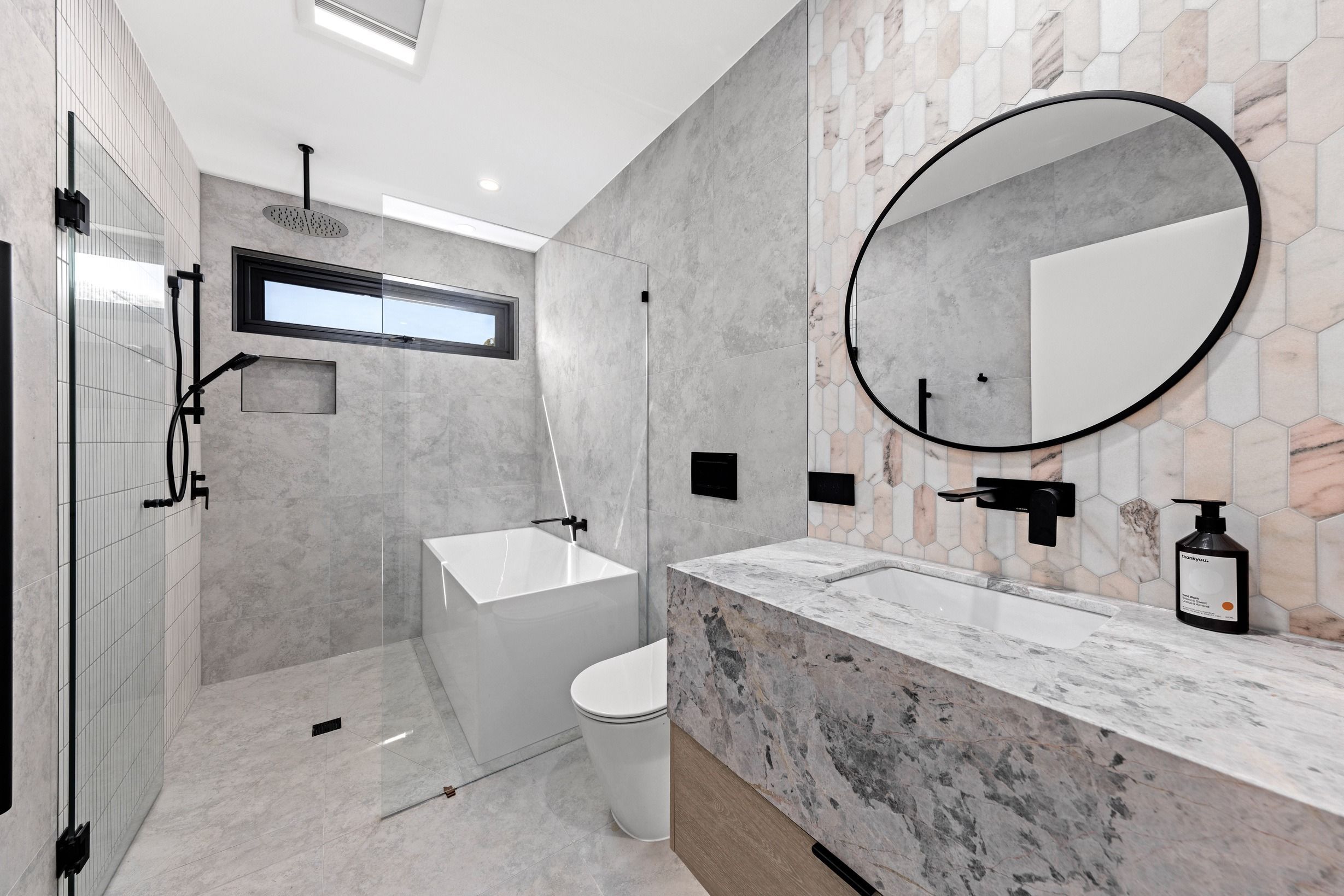 Stone bathroom and black fixtures in the completed Glen Iris residence.
