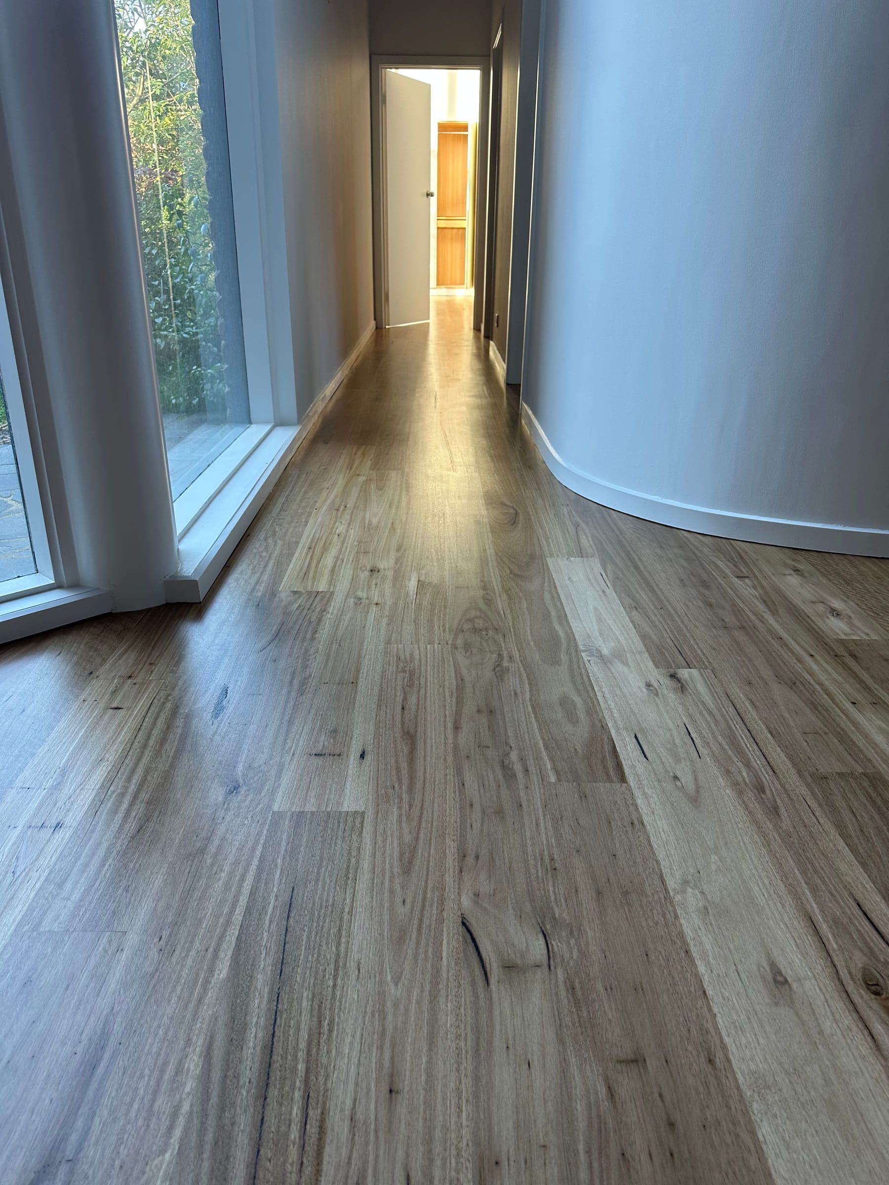 Straight-plank solid Blackbutt flooring through a narrow hallway in the Malvern residence.