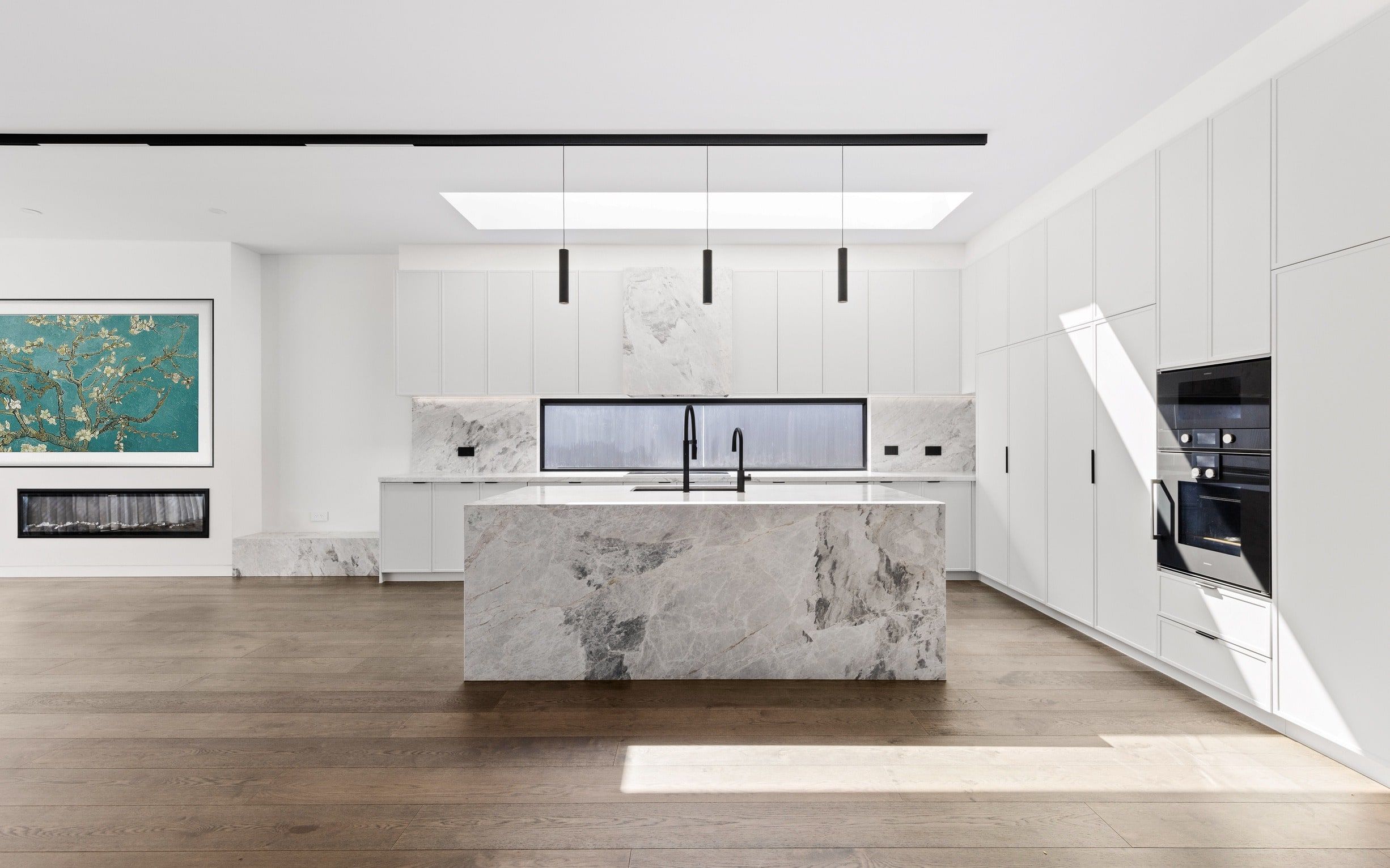 Light-filled Glen Iris kitchen with wide-board timber flooring and a stone island