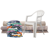 A stack of colorful folded clothes, a white plastic chair, and several rolled-up carpets.