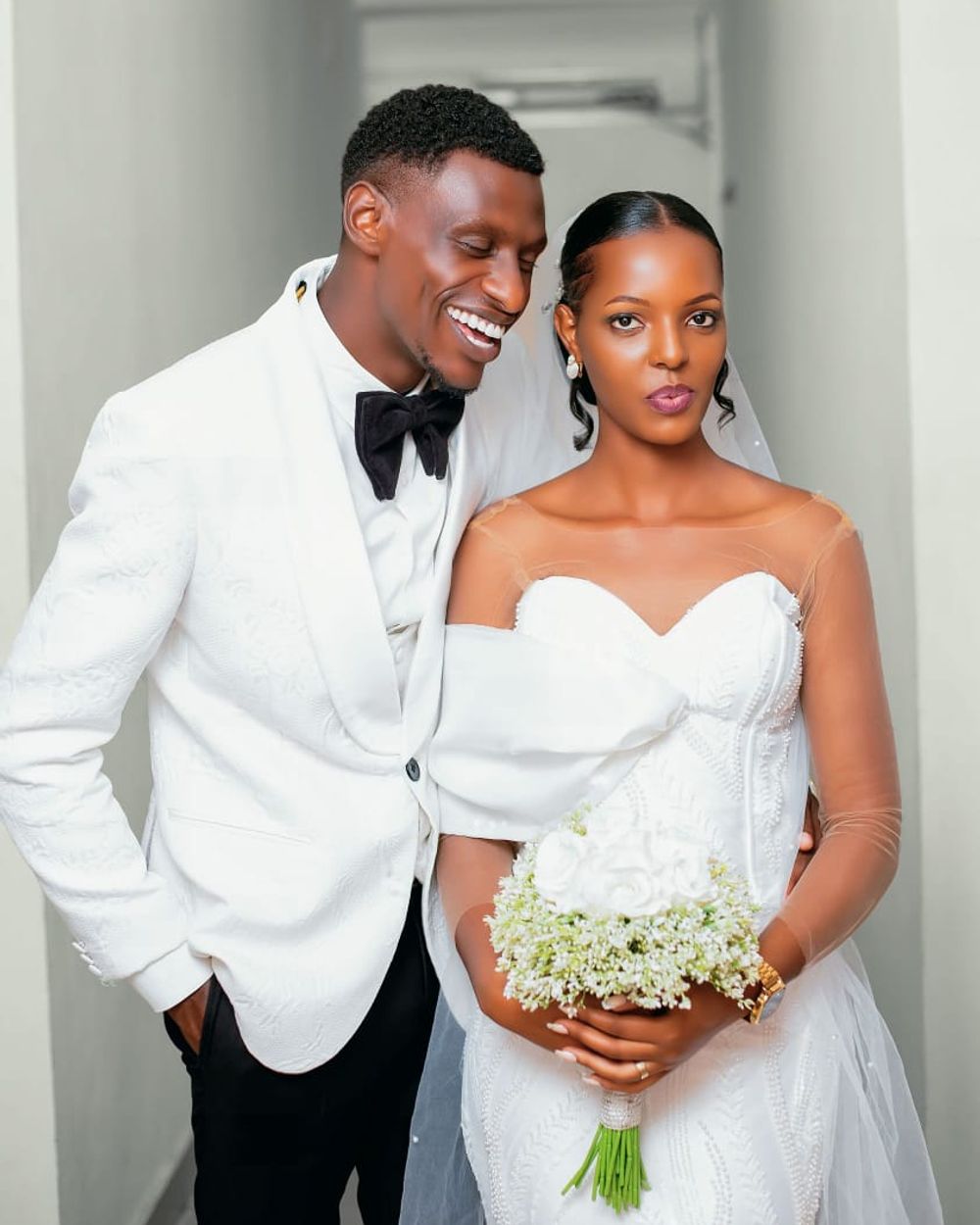 Bride and groom sharing a candid moment in a hallway, wedding day