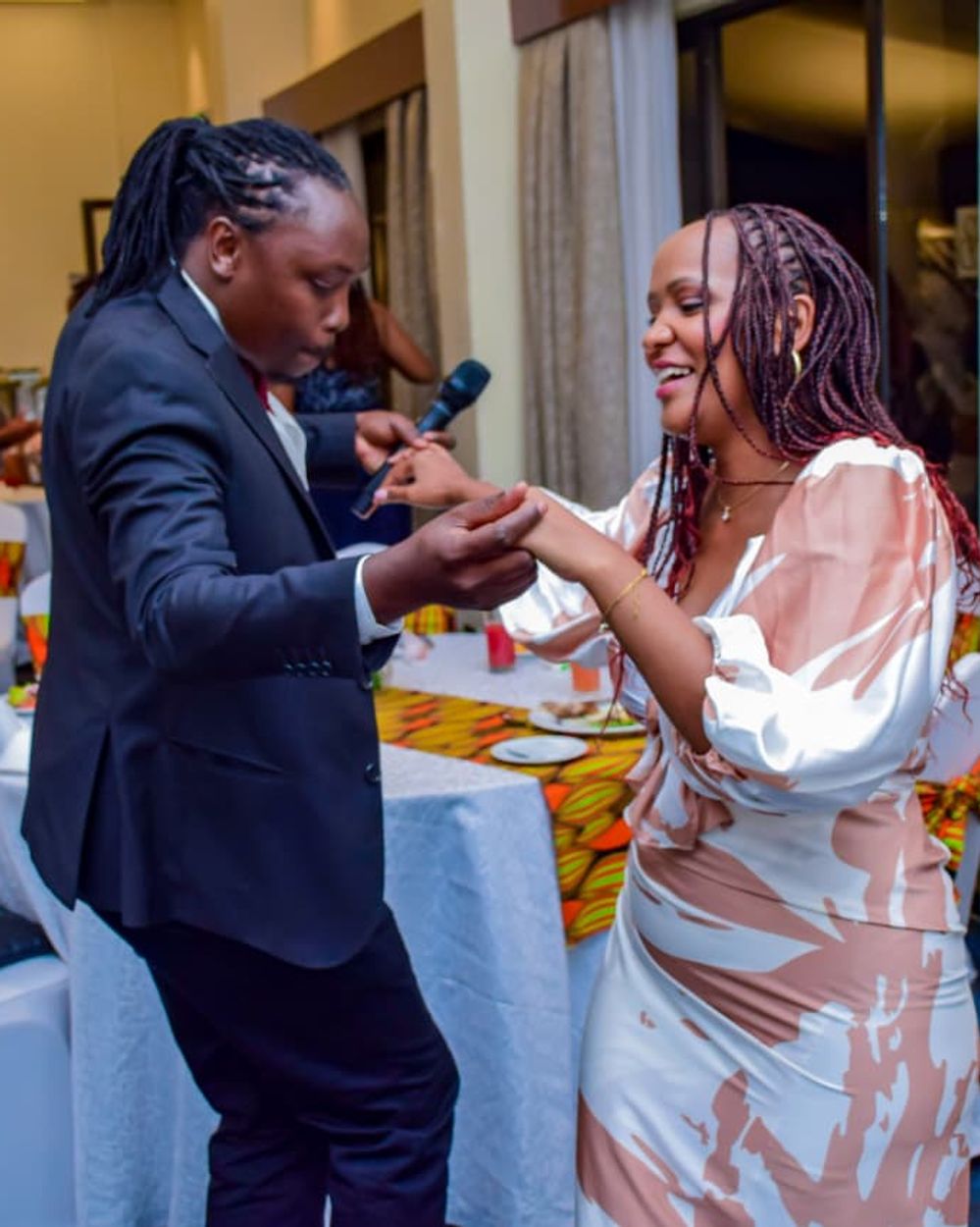 Emcee and guest sharing a light moment during a wedding reception