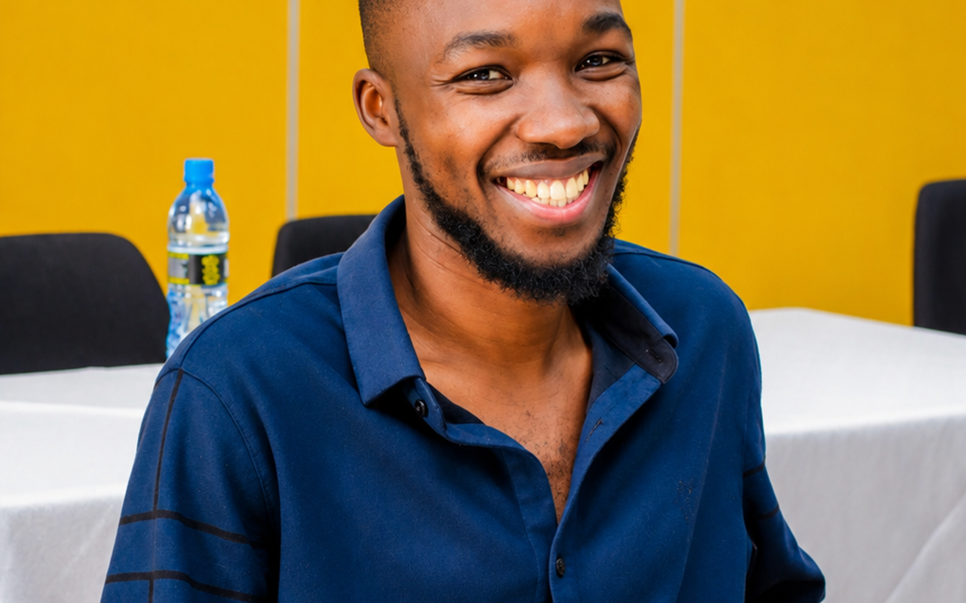 Smiling attendee in a blue shirt at a business event