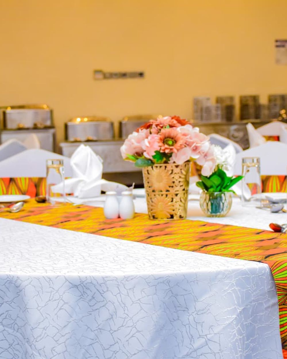 Reception table styling with African-print runner and floral centerpiece
