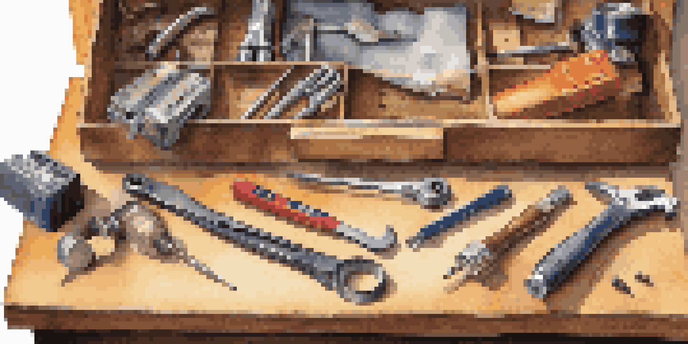 A neatly arranged home maintenance toolkit on a wooden workbench, showcasing various hand tools like a hammer and screwdrivers under warm lighting.