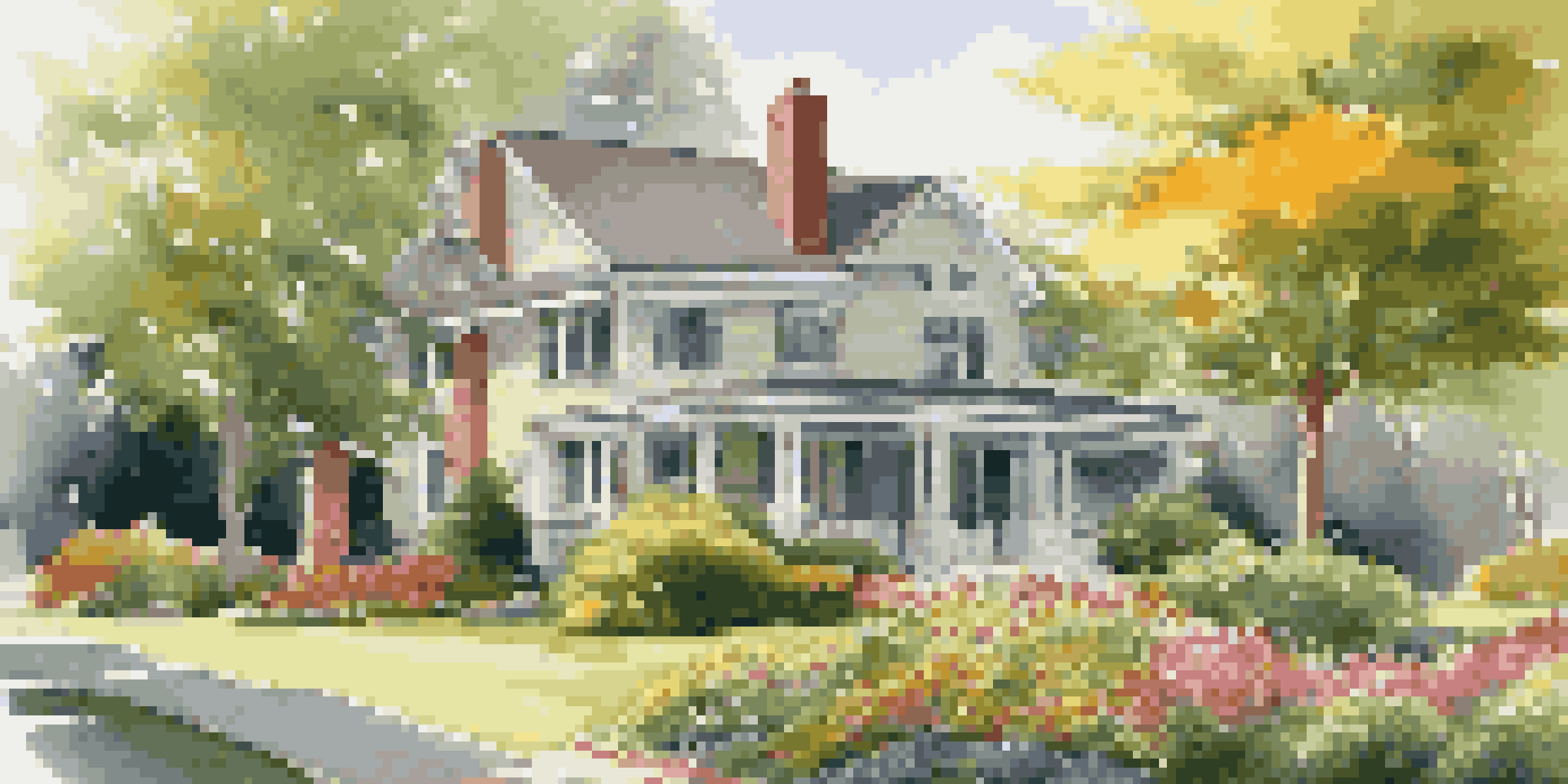 A landscaped front yard with a mix of trees and colorful flowers, illuminated by warm afternoon sunlight.