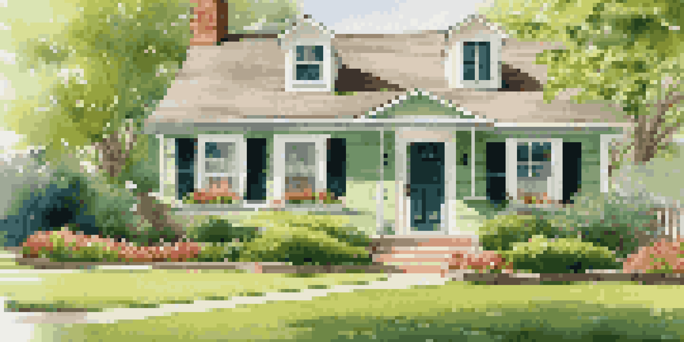 A beautiful home with a well-kept lawn and blooming flowers in spring, under warm sunlight.