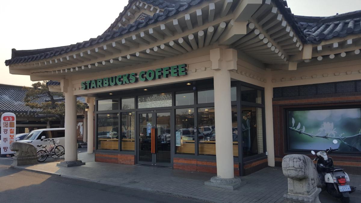 The Starbucks in Gyeongju, built as a traditional hanok with a curved tiled roof and stone guardians flanking the entrance.
