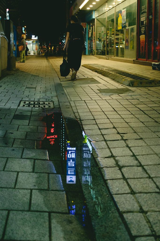 A Seoul street at night, busy and well lit.