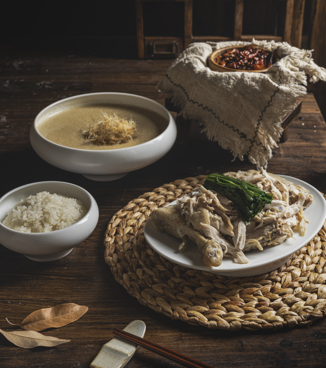 Muguok's North Korean-style samgye baekban, with chicken soup, shredded chicken, and rice served in separate bowls.