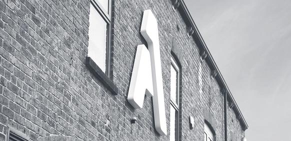black and white photo of brick building with large A letter