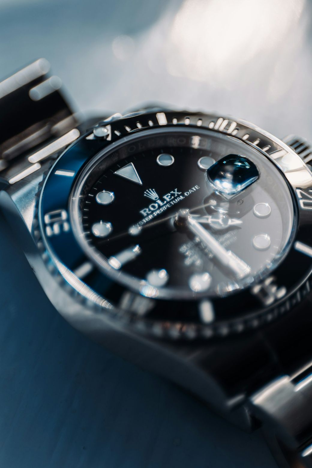 The image features a close-up of a luxury Rolex watch with a black dial, showcasing its prominent features such as luminescent hour markers and a date display. The watch is designed for diving, indicated by its robust build and water-resistant capabilities. — Credit: Photo by Patrick Langwallner on Unsplash