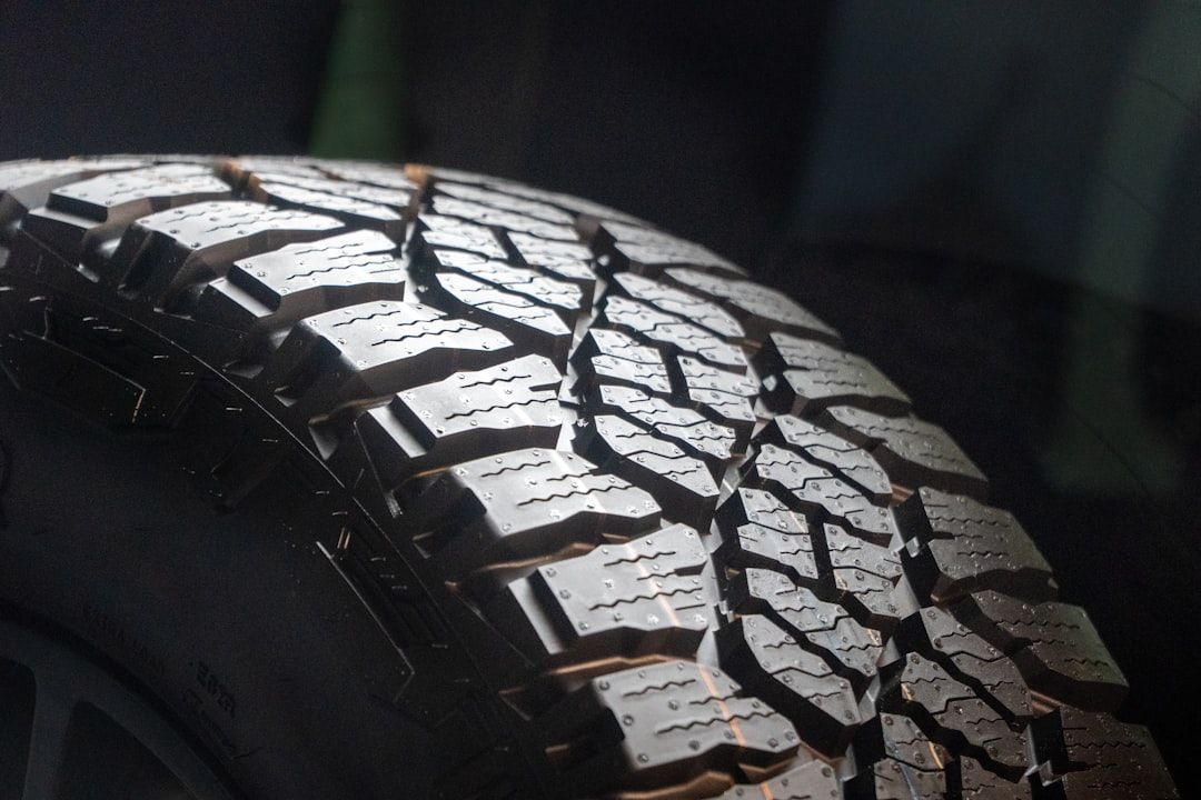 The image features a close-up view of a detailed tire tread, showcasing the intricate patterns designed for traction and grip. The background appears dark, emphasizing the texture and design of the tire.