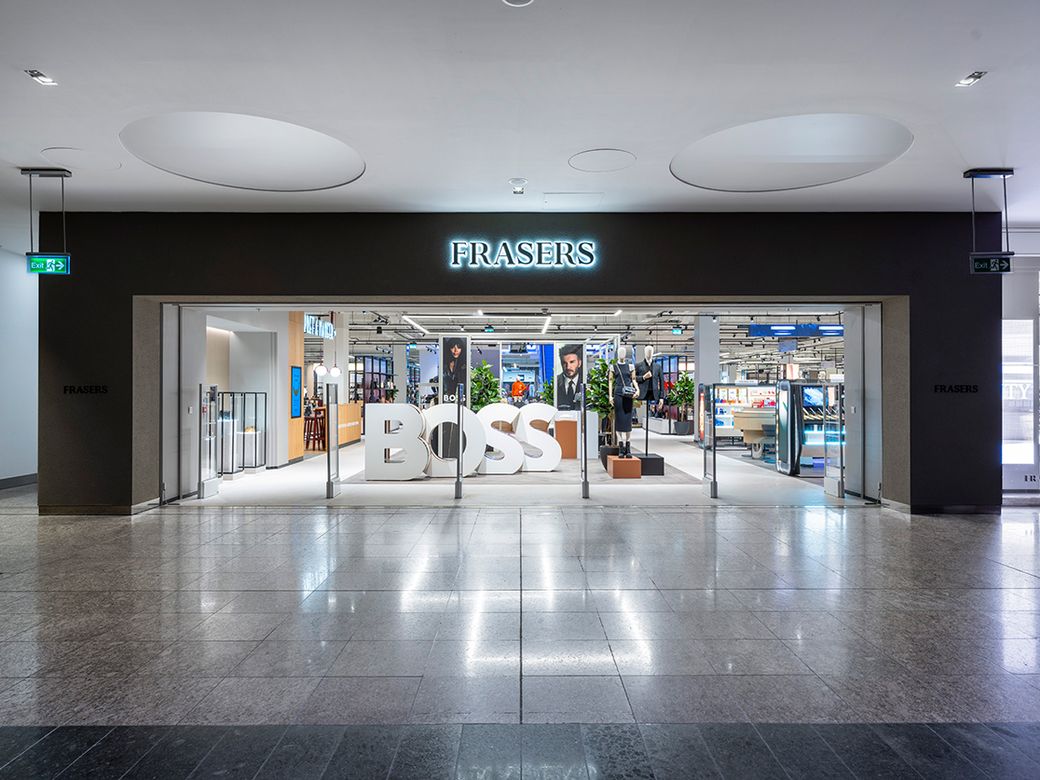 The image shows the entrance to a retail store named 'Frasers'. The store features prominent signage displaying the brand 'BOSS' in large letters. The setting is well-lit and modern, indicative of a shopping environment.