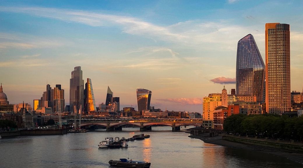 A breathtaking view of the London skyline during sunset, showcasing a blend of modern skyscrapers and historical architecture along the River Thames. The scene highlights iconic landmarks and reflects the city's vibrant energy. — Credit: Photo by Bosh Ar on Unsplash