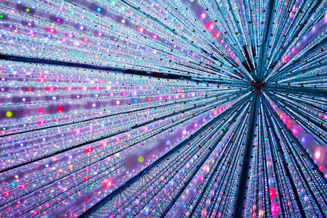 An abstract composition of vibrant lights and colors creating a dynamic visual effect. The arrangement suggests movement as if the lights are radiating from a central point.