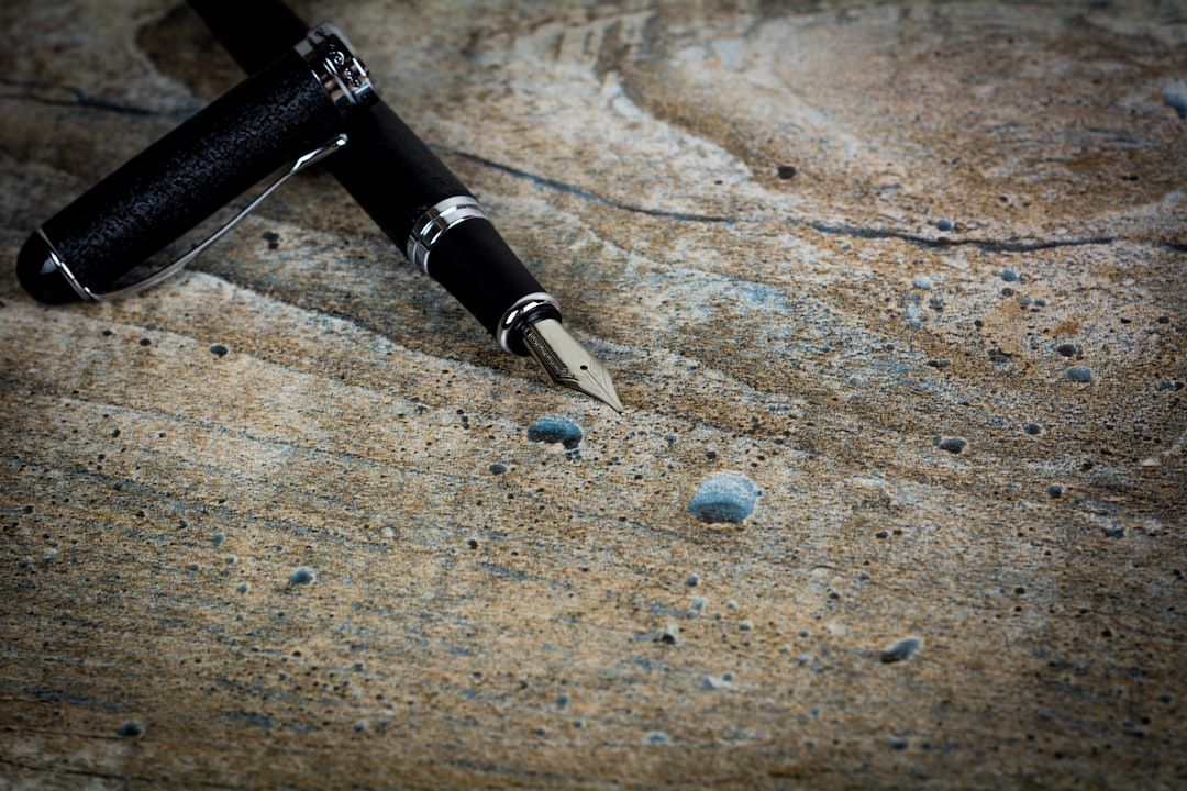 The image features a close-up view of a luxurious fountain pen resting on a weathered wooden surface. The pen's intricate details and the texture of the wood provide a contrast that highlights its elegance.