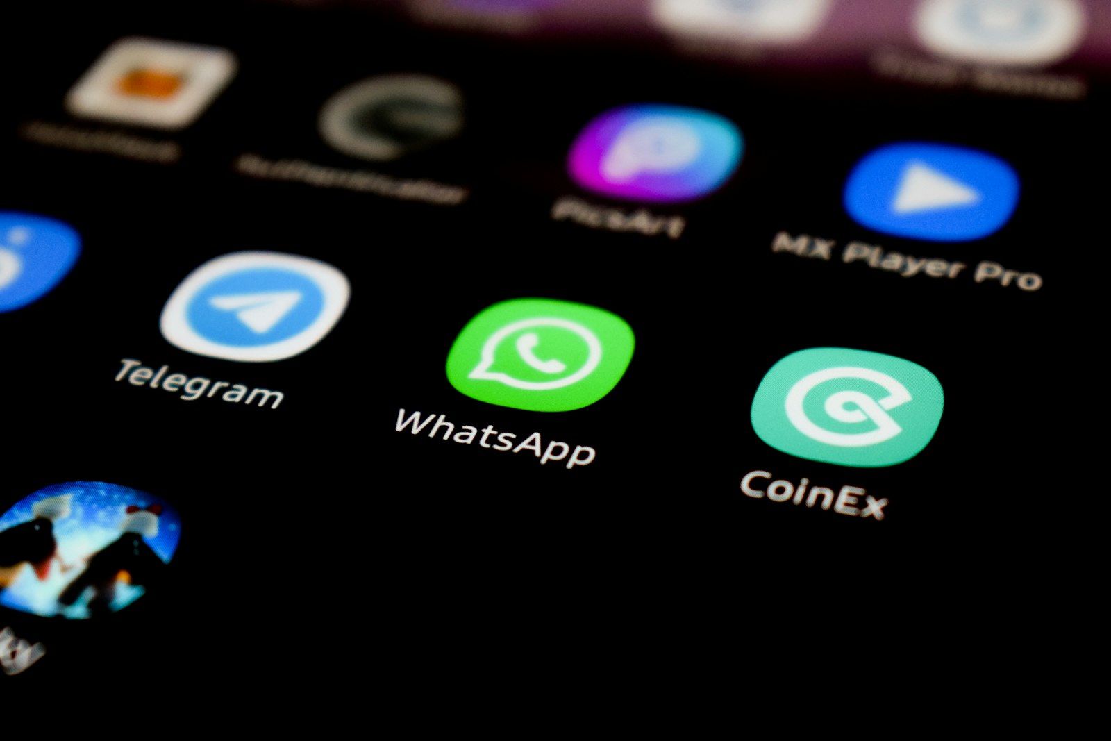 The image displays a close-up of various application icons on a smartphone screen, including messaging and cryptocurrency-related apps. Prominently featured are the WhatsApp, Telegram, and CoinEx logos.