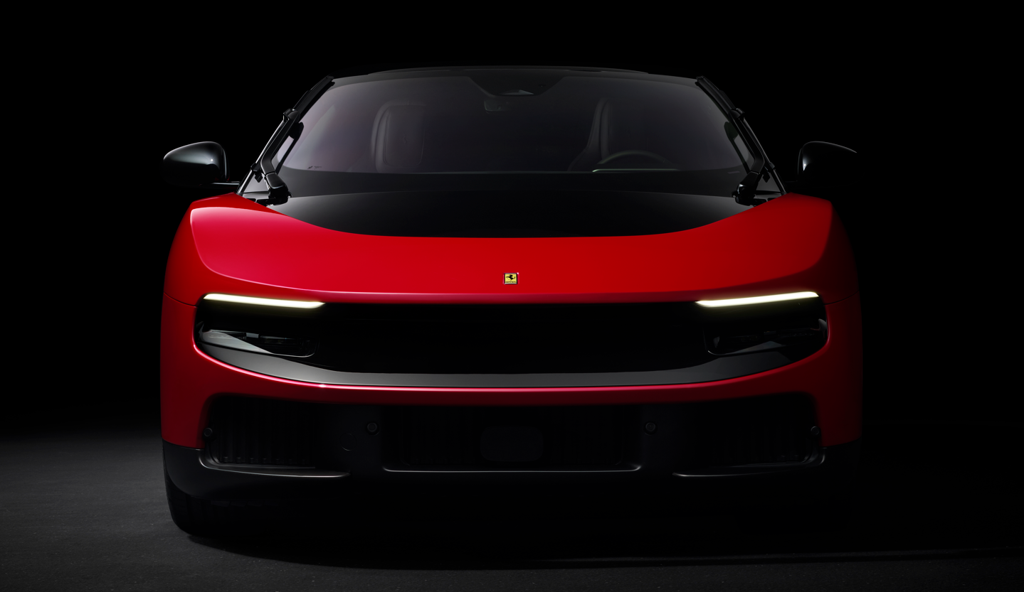 The image features a close-up view of a sleek red sports car, a Ferrari Luce EV, against a dark background, highlighting its aerodynamic design and distinctive features. The car's front fascia displays modern styling elements that suggest high performance.
