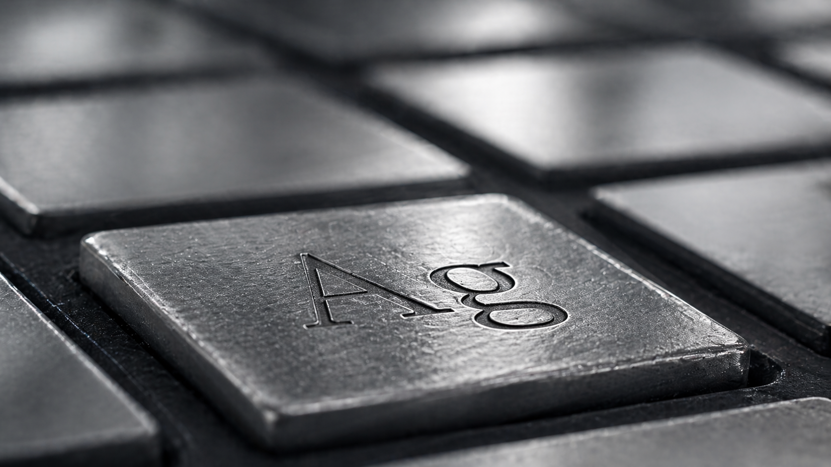 A close-up view of a metallic keyboard key featuring the chemical symbol 'Ag', which represents silver in the periodic table. The image highlights the texture and shine of the key, emphasizing its metallic finish.