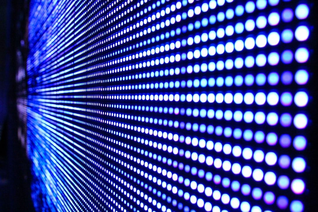 The image features a close-up view of a digital display with a pattern of blue and white LED lights. The lights are arranged in a grid format, creating a vibrant and dynamic visual effect.