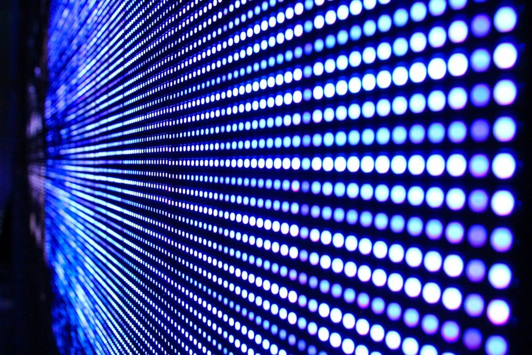 The image features a close-up view of a digital display with a pattern of blue and white LED lights. The lights are arranged in a grid format, creating a vibrant and dynamic visual effect. — Credit: Photo by Justin Lane on Unsplash