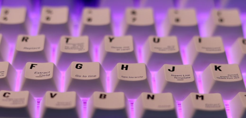 The image shows a close-up of a computer keyboard, specifically the keys illuminated with a purple backlight. The keys display various labels, suggesting functionality related to data processing or programming. — Credit: Photo by Skyler H on Unsplash