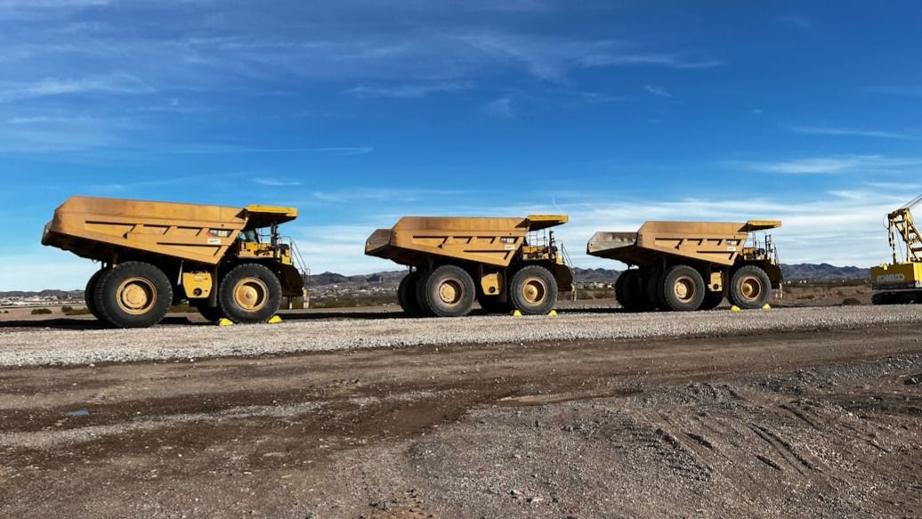 Three Caterpillar 777G mining haul trucks at work in Nevada.