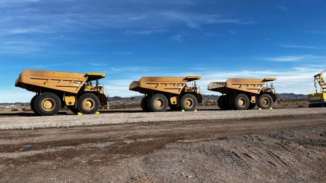 Three Caterpillar 777G mining haul trucks at work in Nevada. — Credit: Photo by Boom & Bucket on Unsplash