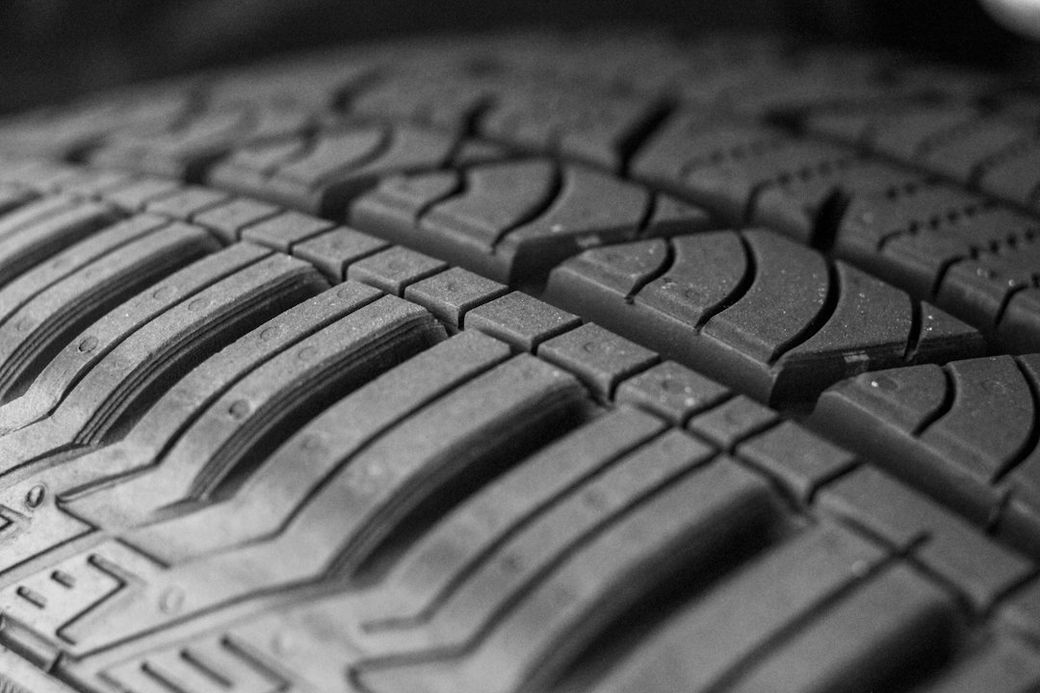 The image features a close-up view of a textured tire tread. The intricate patterns of the tire showcase the grip and design elements typical of performance tires. — Credit: Photo by Yvette S on Unsplash