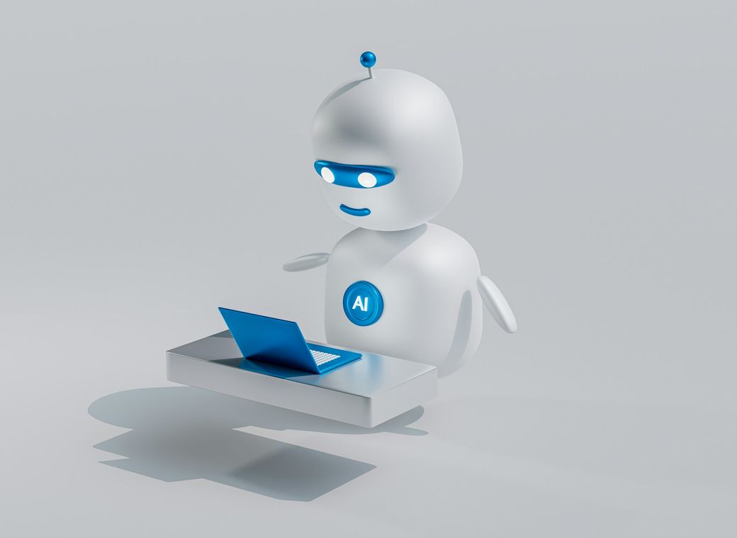 A stylized robotic character is depicted interacting with a laptop on a sleek surface. The robot, featuring blue accents, appears engaged in tasks related to artificial intelligence. — Credit: Photo by Mohamed Nohassi / Unsplash