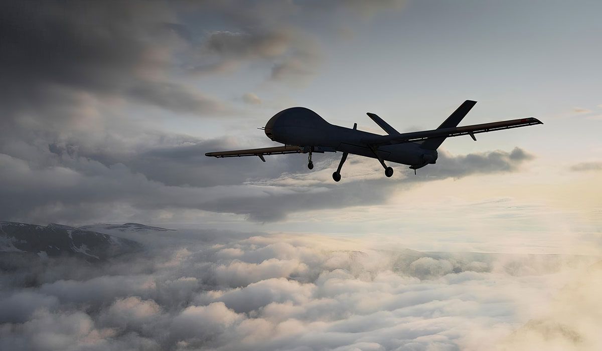 The image depicts a drone flying through a cloudy sky during sunset. The silhouette of the drone is clearly visible against the backdrop of dramatic clouds and soft golden light.