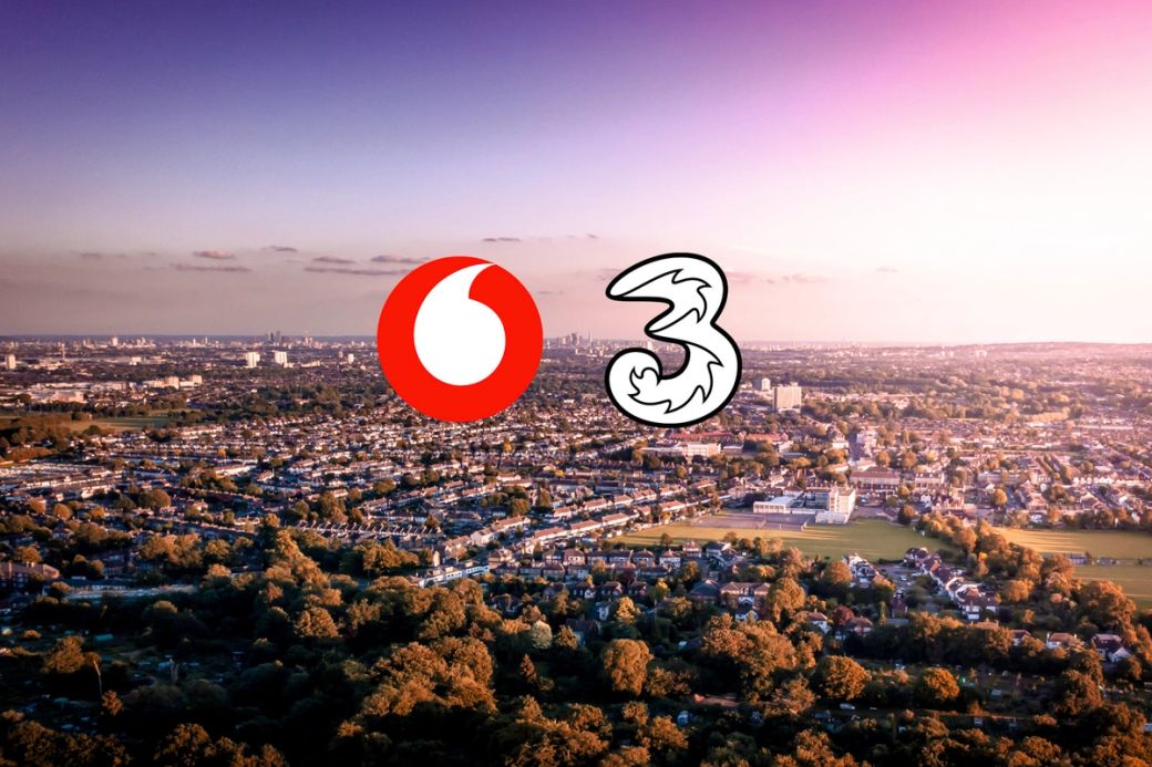 An aerial view of a cityscape featuring urban development and greenery. Prominently displayed are the logos of Vodafone and a stylized number 3.