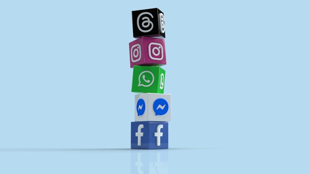 The image features a stack of colorful blocks, each displaying recognizable social media logos. The blocks are arranged vertically against a light blue background, showcasing popular platforms. — Credit: Photo by Shutter Speed on Unsplash