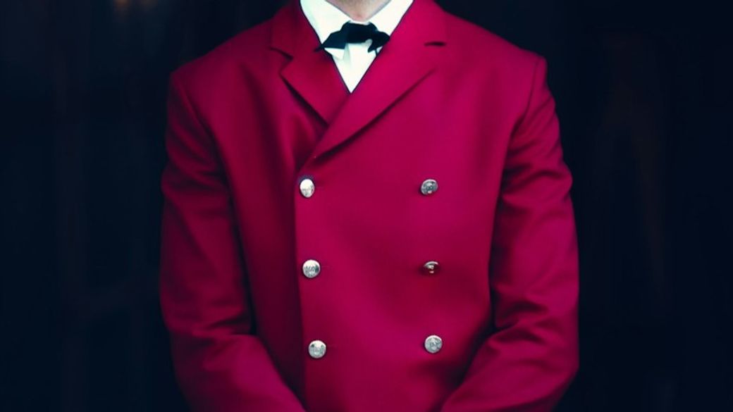 a man in a red coat — Credit: Photo by Ibrahima Toure on Unsplash
