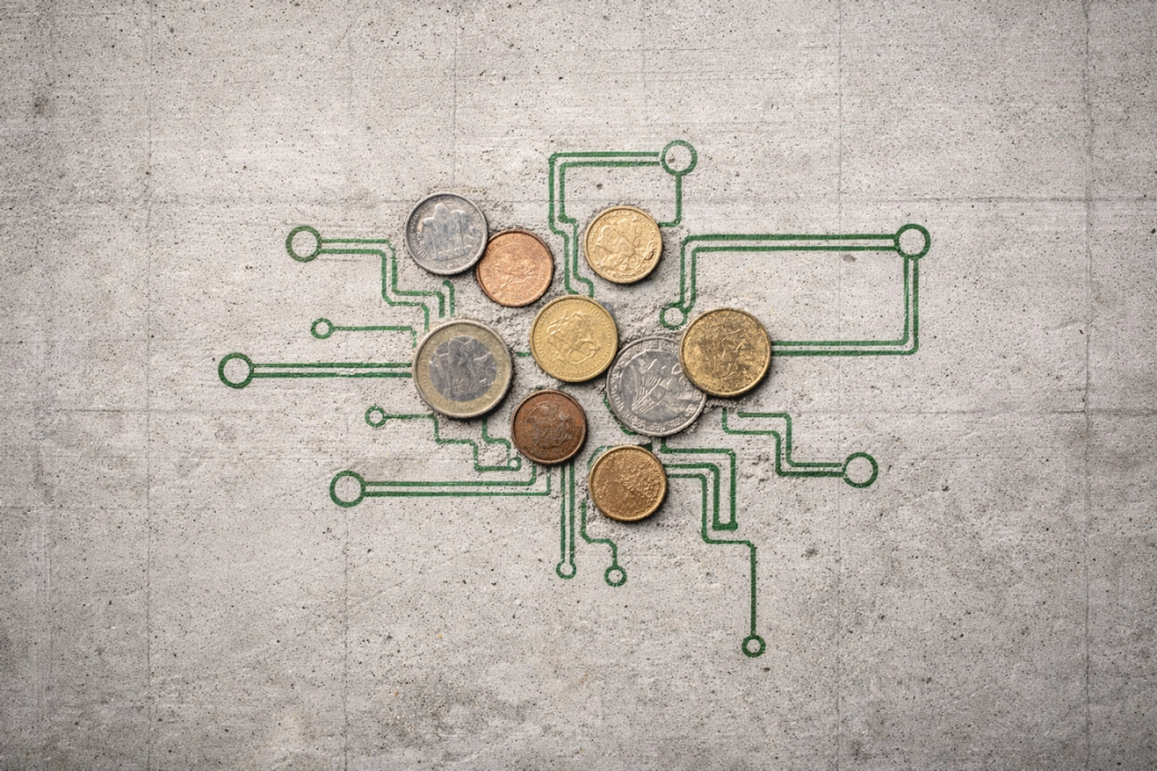The image features a collection of various coins arranged on a concrete surface, overlaid with a green circuit-like pattern. This composition blends currency with technology, suggesting themes of finance and digital innovation.