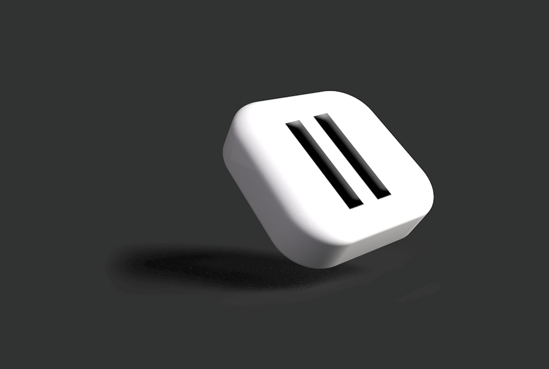 A 3D rendered pause button symbol, depicted in a minimalist style against a dark background. The button appears to hover, casting a subtle shadow.