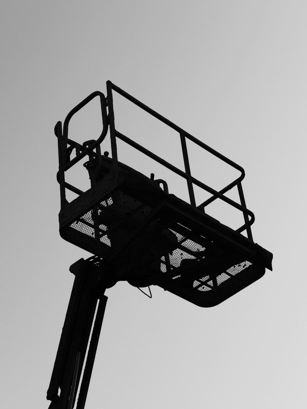 The image features the silhouette of a construction lift or cherry picker against a clear sky. The structure includes a platform with railings, commonly used for accessing high places during construction or maintenance work. — Credit: Photo by Sebastian Schuster on Unsplash