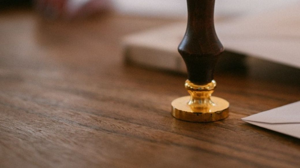 A wooden wax seal stamp on a table — Credit: Photo by Raymond Petrik on Unsplash