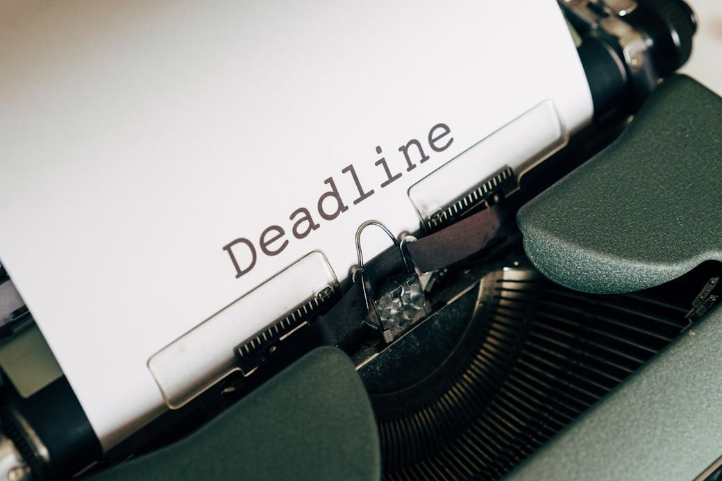 The image features a close-up of a vintage typewriter with a piece of paper loaded in it. The word 'Deadline' is prominently typed on the paper, suggesting a focus on writing or journalism. — Credit: Photo by Markus Winkler on Unsplash