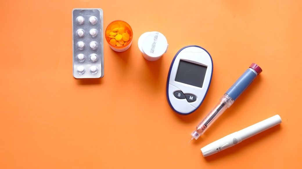 insulin pen, diabetic measurement tools and pills on orange background — Credit: Photo by Towfiqu barbhuiya on Unsplash