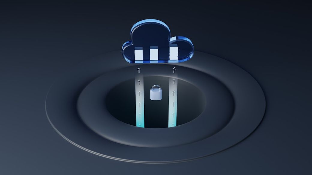 The image depicts a stylized cloud icon above a circular base featuring a padlock and arrows pointing upward, symbolizing data security and cloud computing. The design emphasizes modern digital technology with a sleek and contemporary aesthetic. — Credit: Photo by Growtika on Unsplash