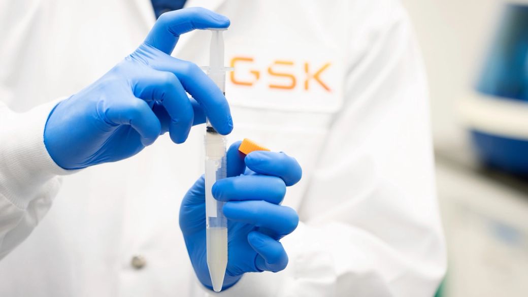A laboratory technician in a white coat and blue gloves is preparing a pipette with a liquid sample. The individual is focused on the task, indicating a moment of scientific analysis or experimentation.