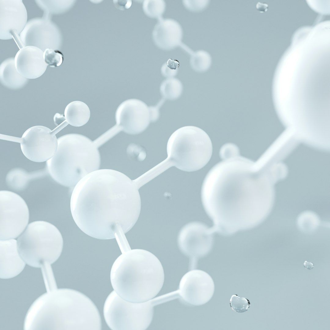 The image features a close-up view of molecular structures, showcasing interconnected spheres that represent atoms. The light background emphasizes the clarity and detail of the molecular connections.