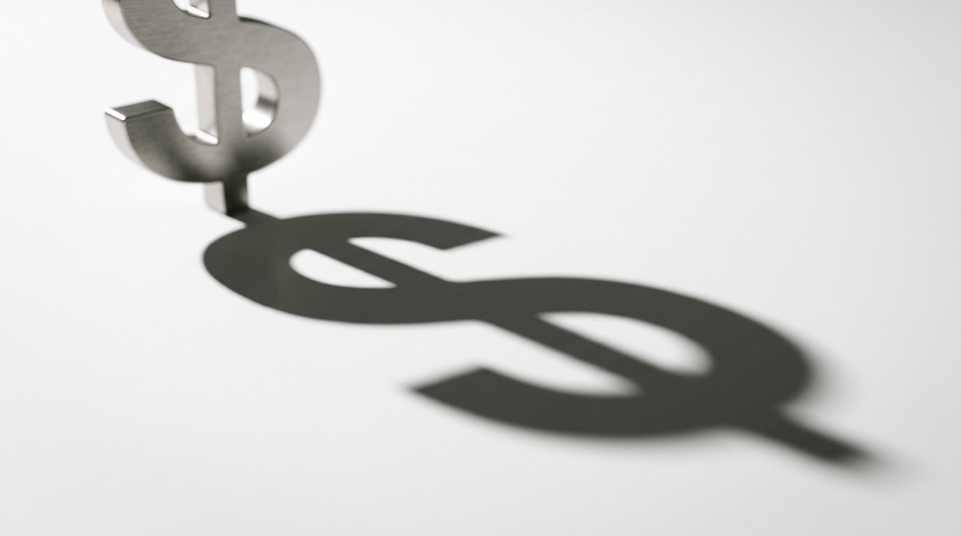 The image features a large dollar sign made of brushed steel, prominently displaying its shadow cast on a pristine white surface. The shadow, elongated and distorted, suggests a surreal representation of financial influence, highlighting the iconic symbol's power beyond its physical form.