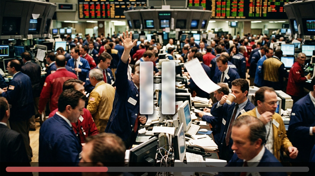 The image captures a bustling stock exchange trading floor at peak activity, where traders are actively engaged, mid-stride between terminals. The scene is vibrant with a blend of colored jackets and suspended movements, including raised hands and paper slips in the air, all under a translucent pause overlay that contrasts with the chaotic background.