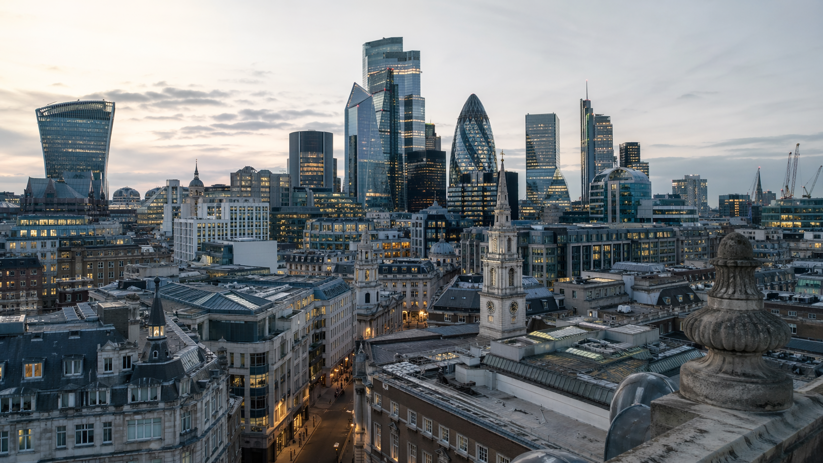 A panoramic view of London's skyline featuring a mix of modern skyscrapers and historic buildings at dusk. The image captures the contrast between the contemporary architecture and the classic structures below, showcasing the city’s dynamic urban landscape.